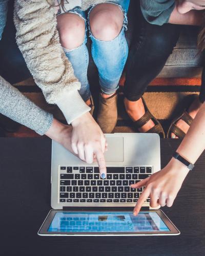 people pointing at laptop